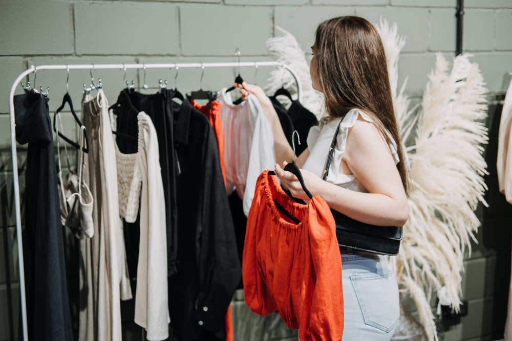 Sustainable fashion, slow fashion, Conscious shopping. Young  woman shopping in modern clothing store.
