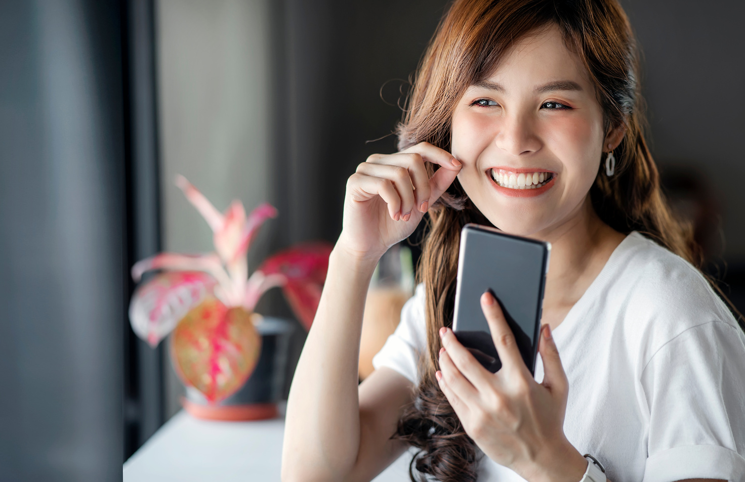 An Asian Woman Smiling Using Mobile Phone